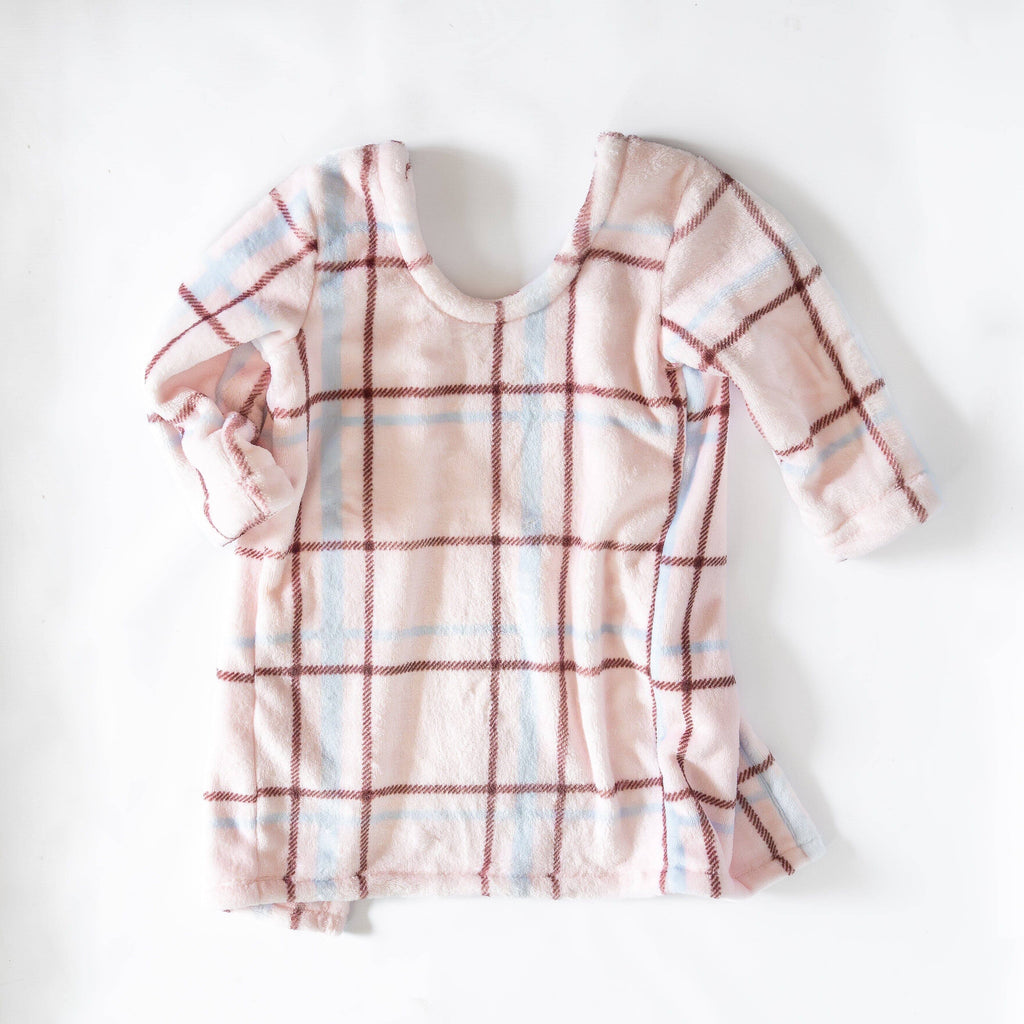 A front view of light pink/cream car seat blankie with a soft, cozy plaid pattern featuring red and blue lines. It is laid flat against a plain white background.